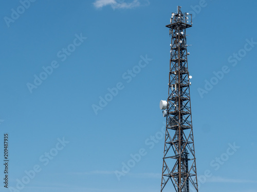 Steel lattice communications tower with an array of dishes for transmission and reception