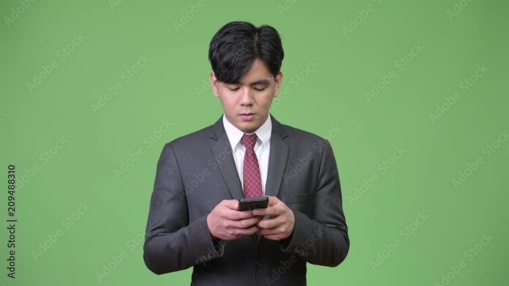 Young handsome Asian businessman using mobile phone Young handsome Asian businessman using mobile phone