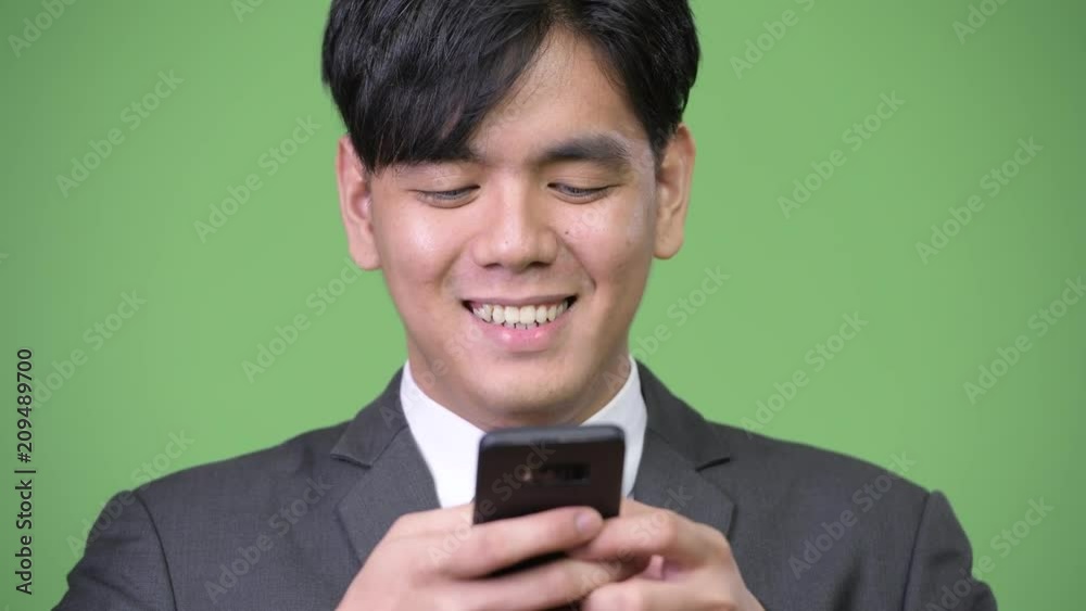 Young handsome Asian businessman using mobile phone Young handsome Asian businessman using mobile phone
