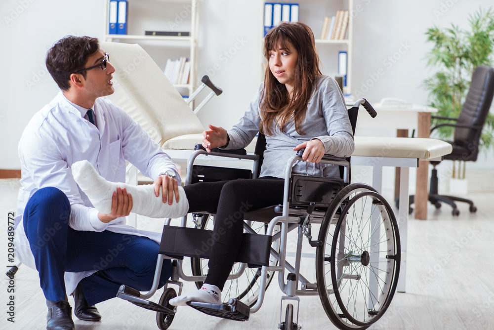 Male doctor examining female patient on wheelchair Male doctor examining female patient on wheelchair