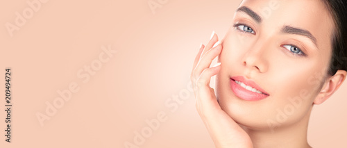 Beautiful brunette girl touching her face. Perfect fresh skin. Spa beauty portrait. Youth and skincare concept, cleansing 