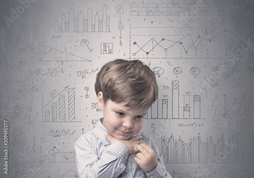 Little boy in front of a grey wall with graphs and statistics around