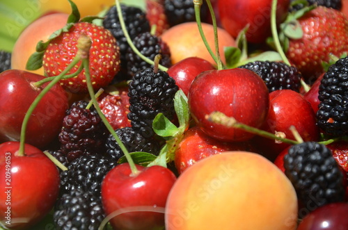 Fototapeta Naklejka Na Ścianę i Meble -  Berries overhead closeup colorful assorted mix of strawberry, blueberry, raspberry, blackberry, red currant in studio on dark background