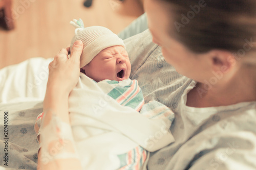 Mother holding her beautiful newborn baby boy in her arms. 