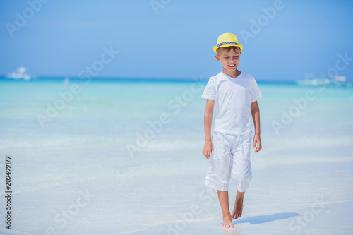 Happy child in yellow hat on beach. Summer vacation concept