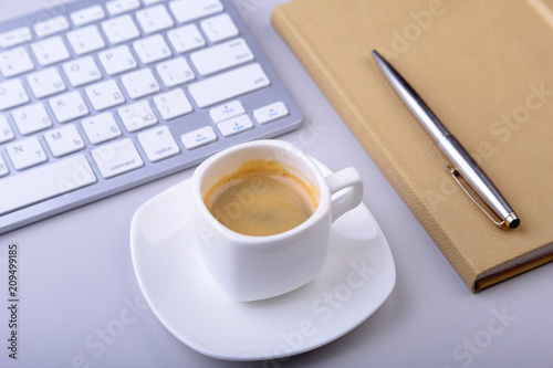 office table with notebook, computer keyboard,, cup of coffee, tablet pc. copy space.