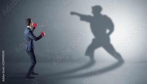 Canvas Print Businessman fighting with his strong karate man shadow