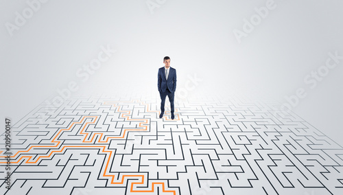 Young entrepreneur standing in a middle of a labyrinth with the solution 
