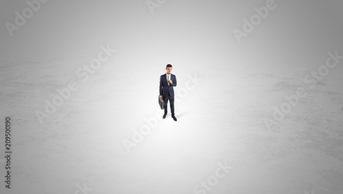 Young businessman standing alone in the middle of an empty space  