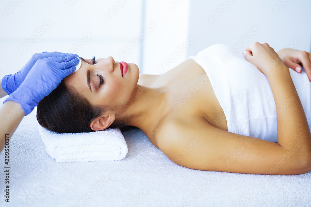 Beauty and Care. Beautiful Young Girl Lying On Massage Tables In Spa Salon. Facial Massage. Hands of a Cosmetologist Make a Facial Massage. High Resolution Beauty and Care. Beautiful Young Girl Lying On Massage Tables In Spa Salon. Facial Massage. Hands of a Cosmetologist Make a Facial Massage. High Resolution