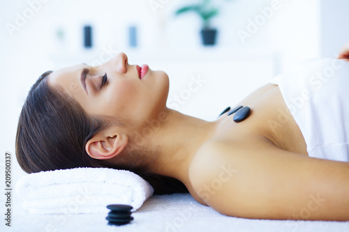 Beauty and Care. Woman in Spa Salon. Young Girl Lying on Massage Tables and Relaxing. Pure Skin and Beautiful Smile. High Resolution