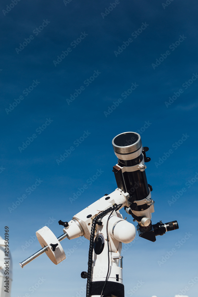 astronomical telescope tube, blue sky background