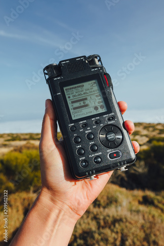 portable audio recorder in hand field recording ambient sounds of nature