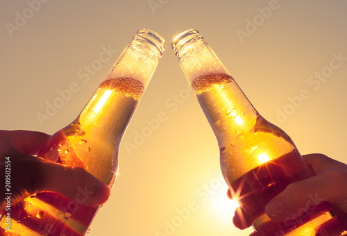 Cheers with ice cold beer on hot summer day. Party and celebration concept. 