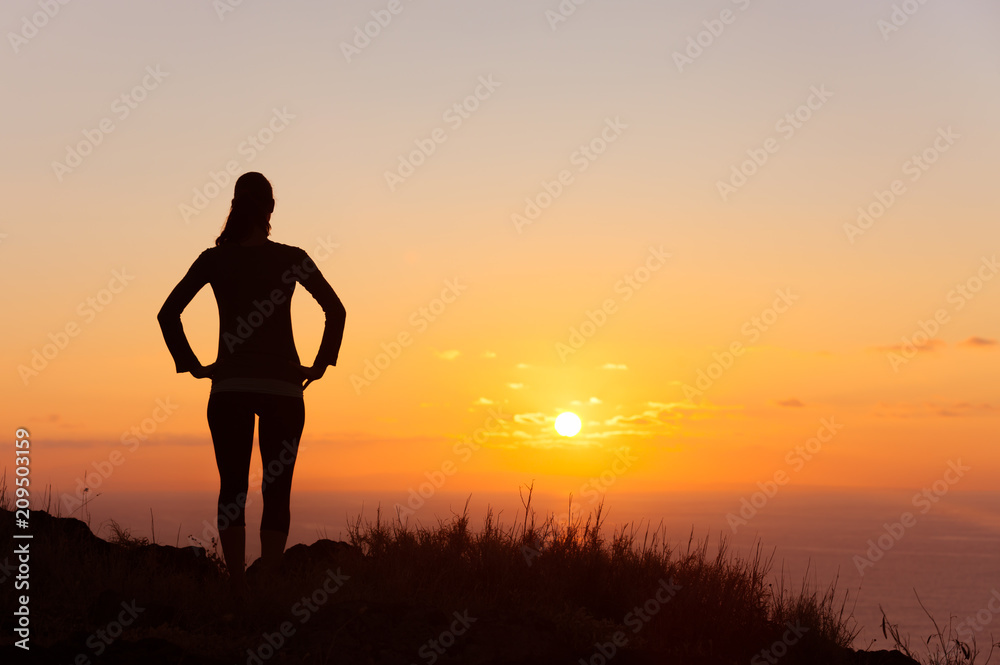 It's a new day concept. Young female standing watching the sunrise. 