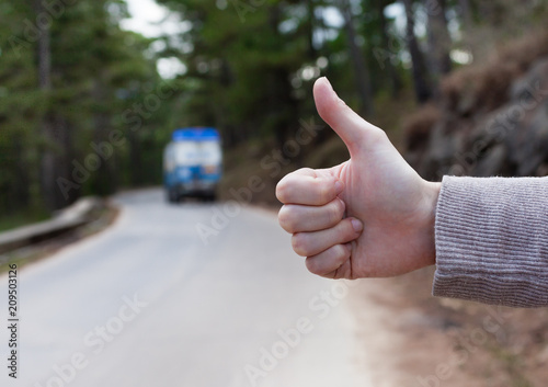 Hand hitchhiking on country road. 