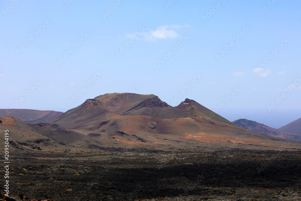 Red mountains and volcanic black land in Lanzarote Island looking like martian landscape, Canary Islands, Spain Red mountains and volcanic black land in Lanzarote Island looking like martian landscape, Canary Islands, Spain