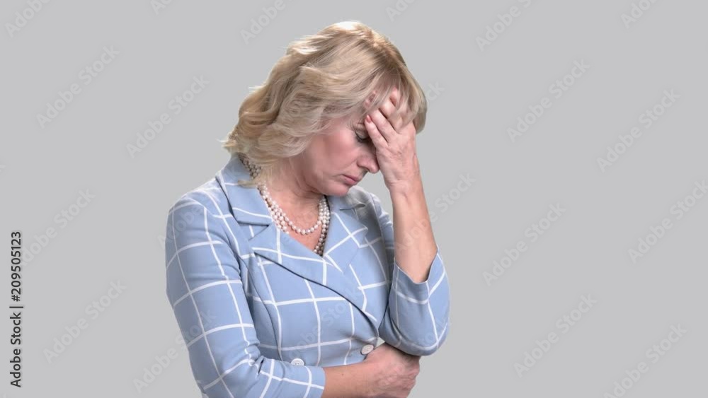 Portrait of worried woman on grey background. Frustrated business woman, side view. Problem and stress expression. Portrait of worried woman on grey background. Frustrated business woman, side view. Problem and stress expression.