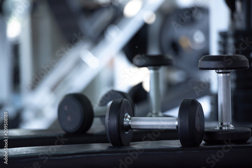 lose up of modern dumbbells equipment in the sport gym , gym equipment concept.