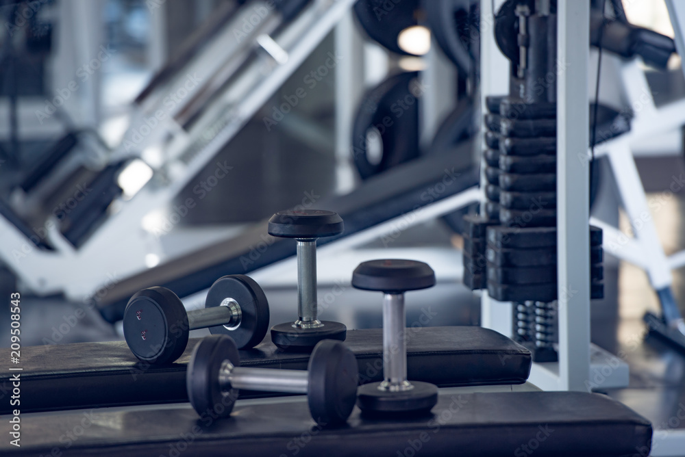 Close up of modern dumbbells equipment in the sport gym , gym equipment concept.