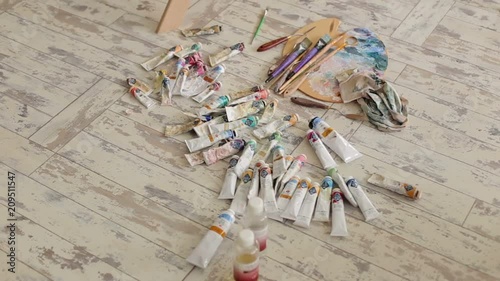 Many multi-colored tubes with oil paint and a palette for drawing on a light wooden surface. Art. Background. photo