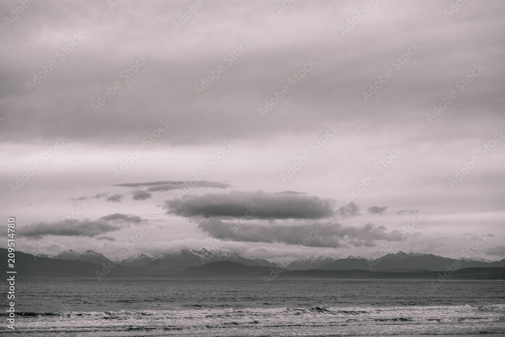 Beautiful scene of the beach with snow mountain at dusk. Black and white effect.