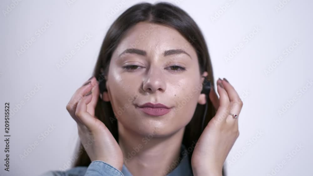 Ragazza con auricolari ascolta la musica e parla al telefono Ragazza con auricolari ascolta la musica e parla al telefono