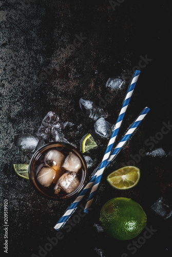 Cuba Libre, long island or iced tea cocktail with strong alcohol, cola, lime and ice, two glass, dark background copy space top view