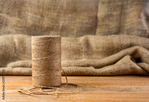 natural rope on wooden table on sackcloth background