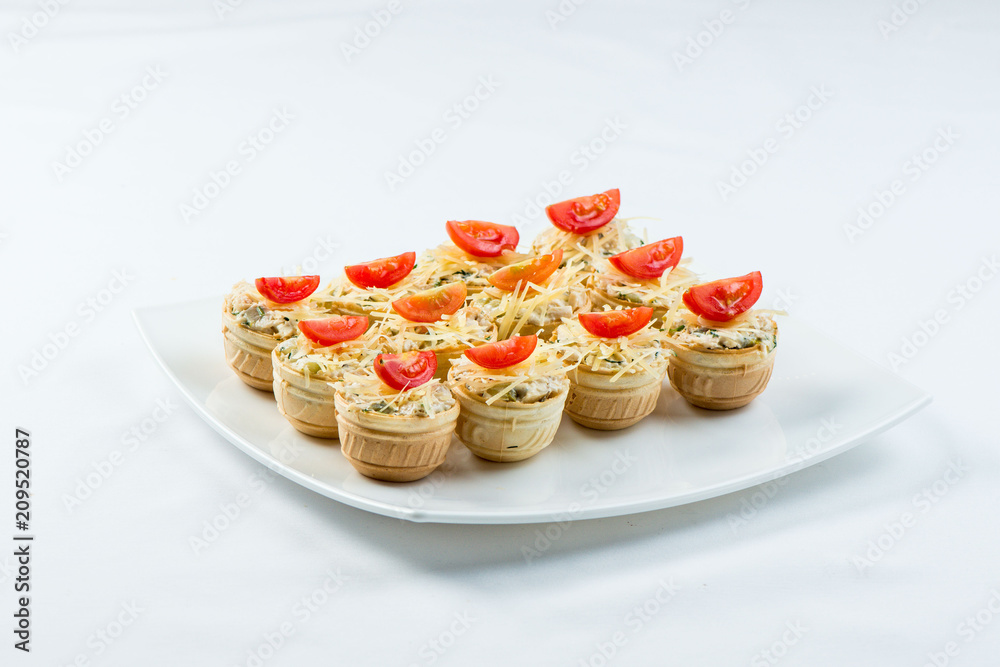 Three baguette slices with liver and apple pate and a thin tomato slice on top. Shallow DOF