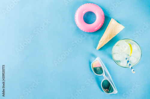 Summer holidays vacation concept background, hat, sunglasses, cooling drink (lemonade, mojito) with ice, ice cream cones, Lifebuoy blue background copy space flatlay above