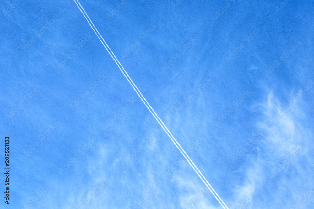Smoke from the jet engine show diagonal with the blue sky in the background. Smoke from the jet engine show diagonal with the blue sky in the background.