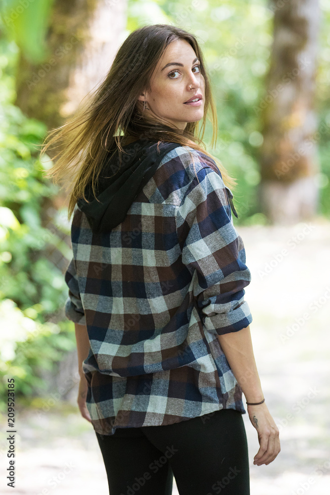 Woman wearing flannel outside in forest Woman wearing flannel outside in forest