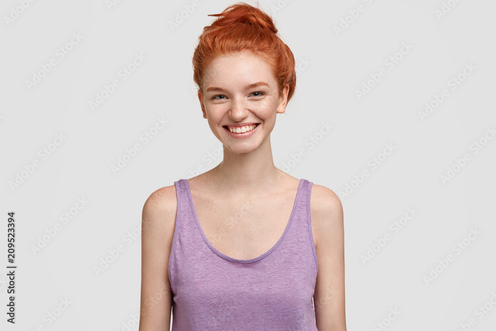 Obraz premium Touched happy freckled female with ginger hair, happy to recieve confession in love, smiles positively, dressed in casual t shirt, isolated over white background. People, beauty, positive expressions