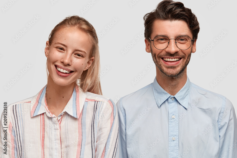 Two companions have fun, rejoice positive news, spend free time together, wear shirts, isolated over white background. Pretty female glad to meet with brother, going to have trip. Friendship concept Two companions have fun, rejoice positive news, spend free time together, wear shirts, isolated over white background. Pretty female glad to meet with brother, going to have trip. Friendship concept