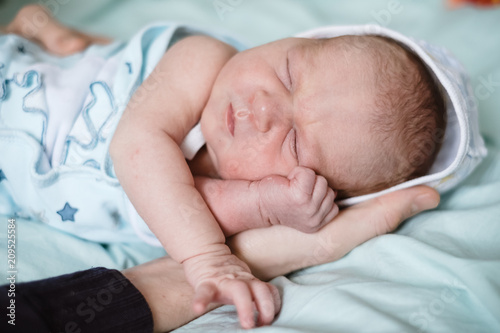 Newborn baby sleeping at home. Close up hands