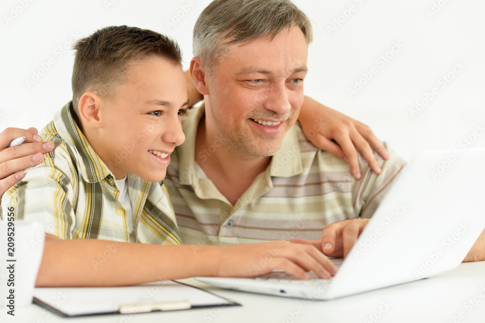 son and father using laptop son and father using laptop