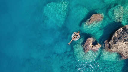 Aerial view at the girl on sea surface. Beautiful composition at the summer time
