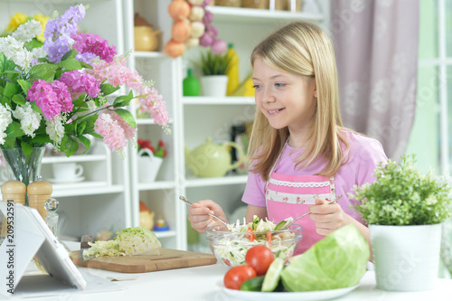 Cute little girl preparing fresh salad