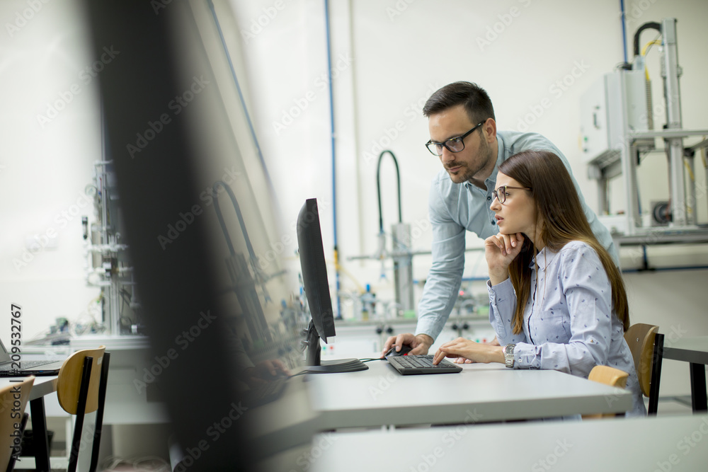 Obraz premium Side view of focused students using desktop pc in classroom
