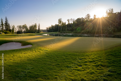 Golf green fairway blue summer sky and sunset sky in the background © catuncia