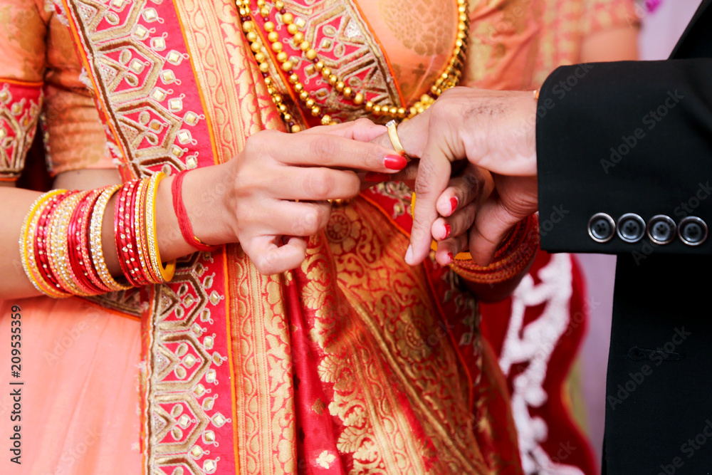 Indian Bride putting ring on indian Groom