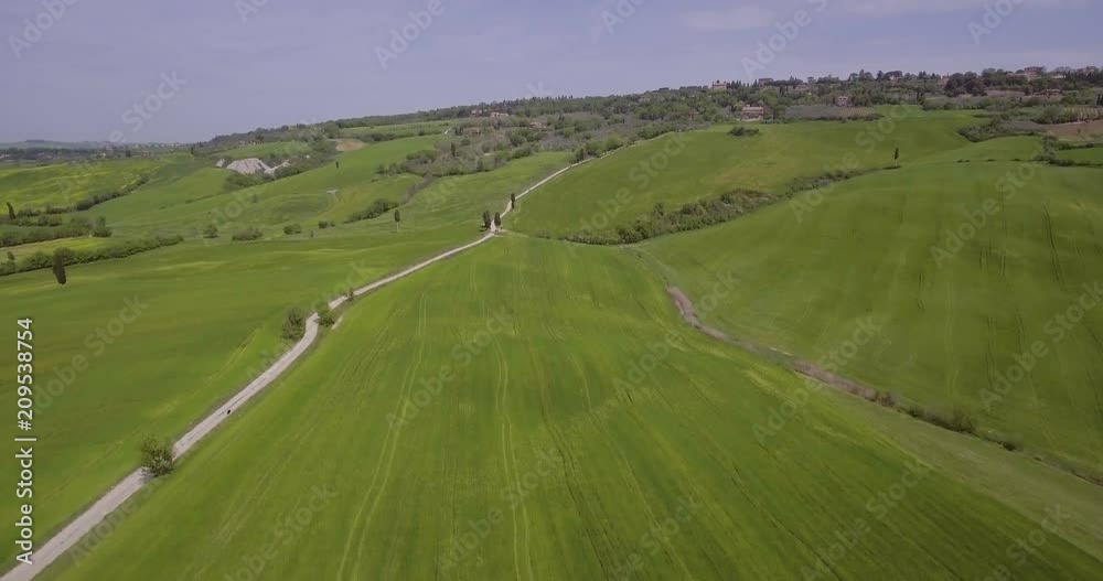 Aerial, beautiful green hills and fields and cypresses landscape in Val d’Orcia in Tuscany, Italy Aerial, beautiful green hills and fields and cypresses landscape in Val d’Orcia in Tuscany, Italy