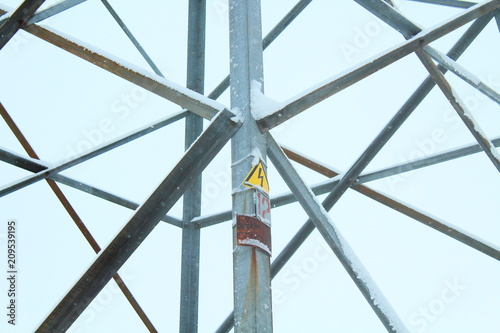 Metal part of the frame of the power line support. Warning sign danger. Close-up. Russia  January  2018.