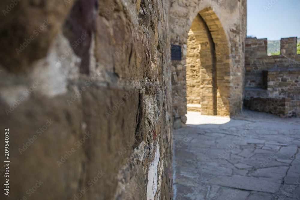 Courtyard of an ancient castle with an arch, view from the wall close-up, selective focus, background