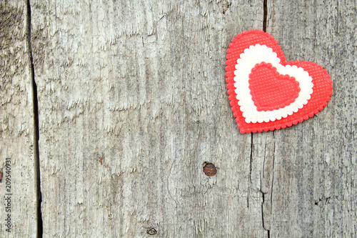 A beautiful heart made of cloth on an old board. Close-up. Background. Texture. Valentine s Day.