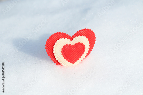 A beautiful heart made of cloth in the snow. Valentine's Day. Close-up. Background. Texture.