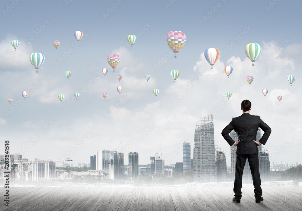 Motivation and inspiration concept with modern cityscape and businessman observing it Motivation and inspiration concept with modern cityscape and businessman observing it