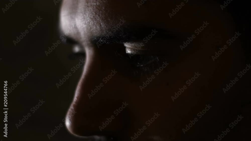 Depressed sad man's eyes in the dark- close up