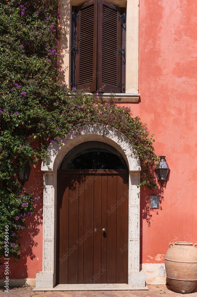 Beautiful door decorated with flowers in italian farm house